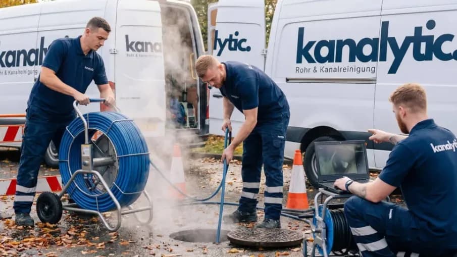 Techniker reinigt Kanal per Hochdruckspülung am Haus