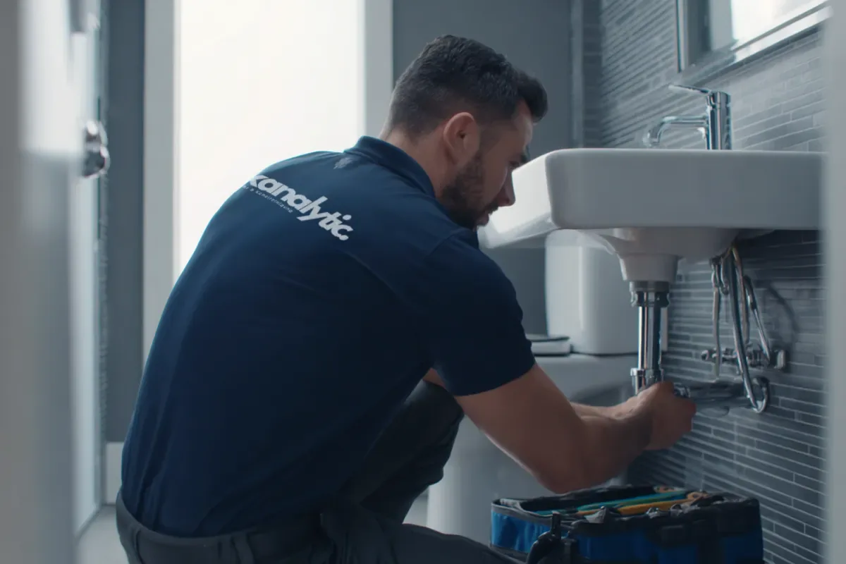 Techniker reinigt einen verstopften Küchenabfluss beim Kunden